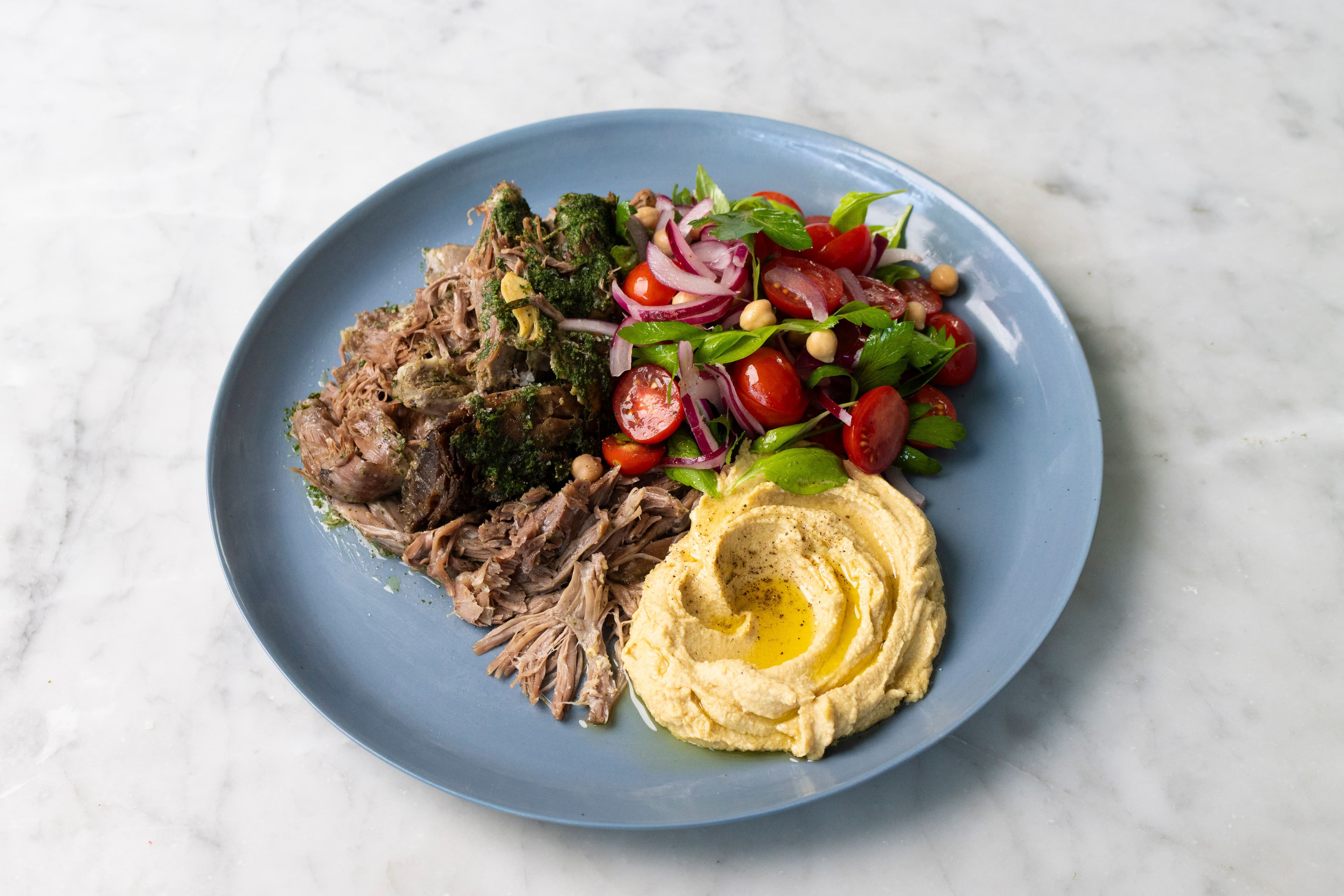 Slow-Cooked Lamb Shoulder with Hummus, Tomato Salad and Mint Salsa